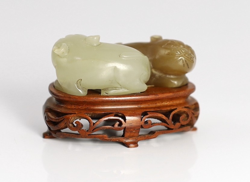 A Chinese pale celadon and brown jade group of two cats, 19th century, 5.1cm, wood stand, tiny chips